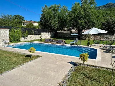 a swimming pool in a yard with a table and chairs at Green House in Virpazar