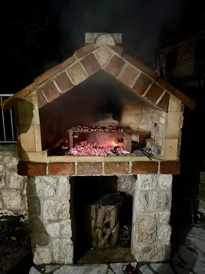 a brick oven with a fire inside of it at Green House in Virpazar