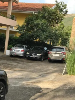 three cars parked in a parking lot in front of a building at Apartments Royal in Budva
