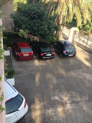 a group of three cars parked in a parking lot at Apartments Royal in Budva