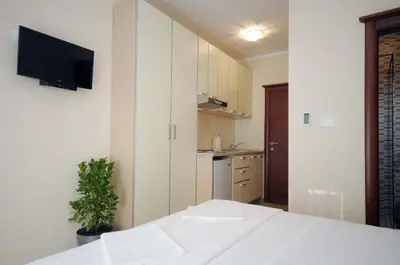 a bedroom with a bed and a tv on a wall at Apartments Royal in Budva