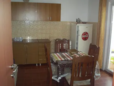 a kitchen with a table and a refrigerator at Apartmani Dado in Ulcinj