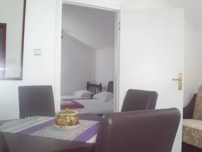 a room with a table and chairs and a mirror at Apartmani Dado in Ulcinj