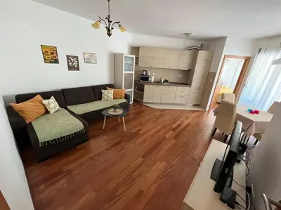 a living room with a black couch and a wooden floor at Cozy Montenegro Experience, 50m from the beach in Petrovac na Moru