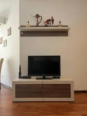 a flat screen tv sitting on top of a entertainment center at Cozy Montenegro Experience, 50m from the beach in Petrovac na Moru