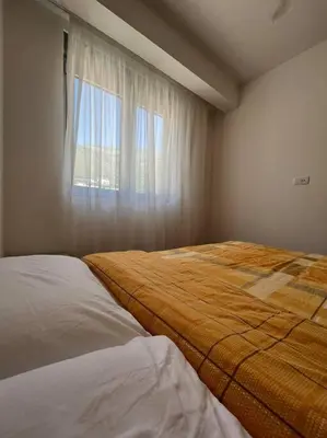 a bedroom with two beds and a window at Cozy Montenegro Experience, 50m from the beach in Petrovac na Moru