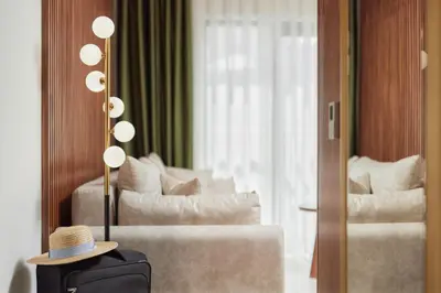 a hotel room with a couch and a hat on a table at Hotel Diplomat by Aycon in Budva