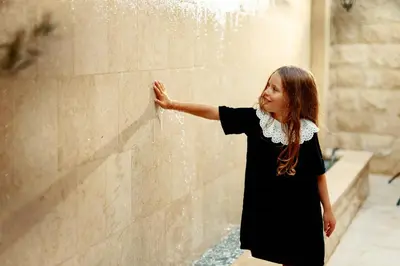 a little girl standing next to a fountain at Hotel Diplomat by Aycon in Budva