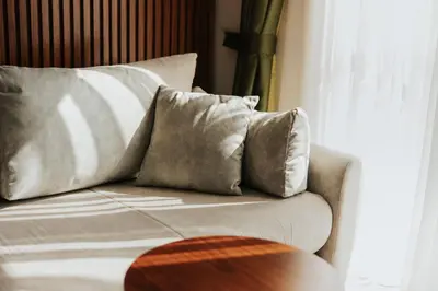 a couch with two pillows sitting next to a window at Hotel Diplomat by Aycon in Budva