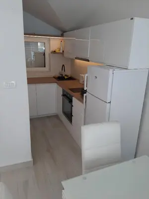 a kitchen with white cabinets and a white refrigerator at Luxury flat with amazing view INES in Kotor