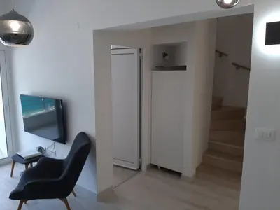 a living room with a chair and a television at Luxury flat with amazing view INES in Kotor