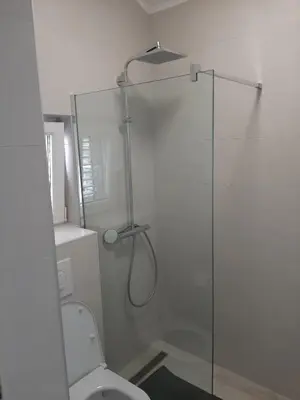 a bathroom with a glass shower with a toilet at Luxury flat with amazing view INES in Kotor