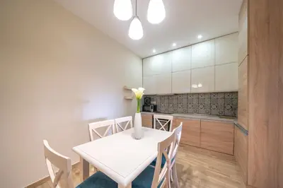 a white dining room with a white table and chairs at Apartments Milunović in Kotor