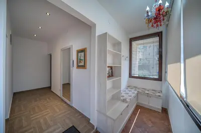 a hallway with white walls and stairs with a window at Apartments Milunović in Kotor