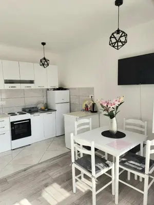 a kitchen with a table with a vase of flowers on it at Apartment Marina 2 in Kotor