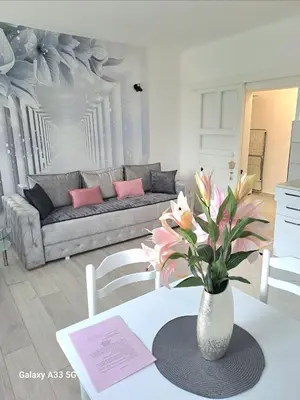 a living room with a vase of flowers on a table at Apartment Marina 2 in Kotor