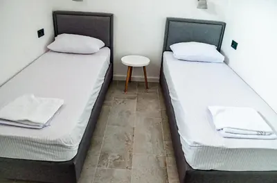 two beds in a small room with a table at Magic Point in Kruče