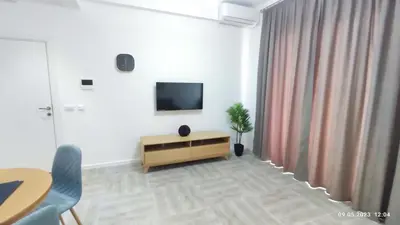a living room with a television and a table and chairs at Apartments LORA Susanj in Bar