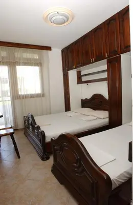 a bedroom with two beds and wooden cabinets at Rooms & Apartments Anka in Bar