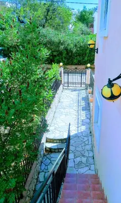 a stone walkway with a gate and a fence at Apartmani LJUBICA in Utjeha