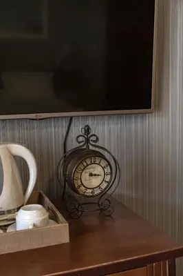 a clock sitting on top of a wooden table at Mali Hotel Porat in Budva