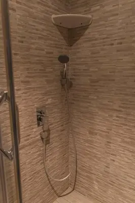 a shower with a hose attached to a wall at Mali Hotel Porat in Budva