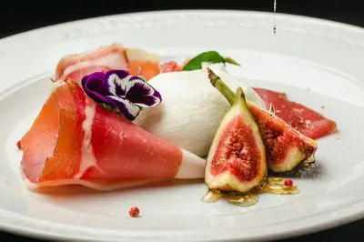 a plate of food with fruit on a table at Mali Hotel Porat in Budva