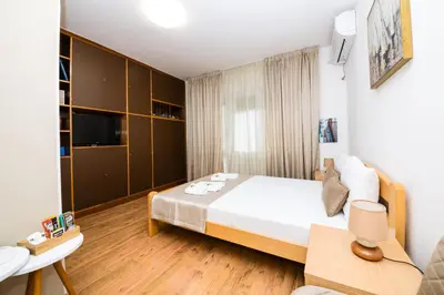 a bedroom with a large bed and a couch at Apartmani F&M in Kotor