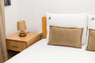 a bedroom with two beds and a night stand with a lamp at Apartmani F&M in Kotor
