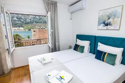 a bedroom with a bed and a large window at Apartmani F&M in Kotor
