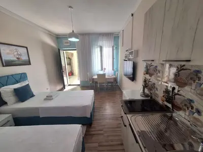a room with two beds and a kitchen with a stove at Montesan Luxury Apartment Beach Front in Sveti Stefan