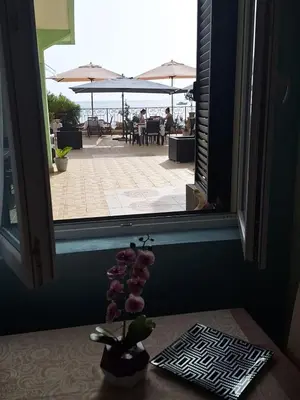 a vase of flowers on a table in front of a window at Montesan Luxury Apartment Beach Front in Sveti Stefan