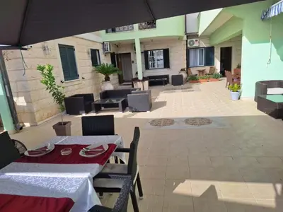 a patio with a table and chairs and an umbrella at Montesan Luxury Apartment Beach Front in Sveti Stefan
