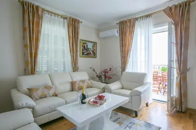 a living room with a white couch and a table at Montesan Luxury Apartment Beach Front in Sveti Stefan