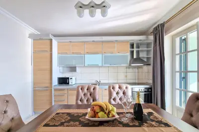 a kitchen with a table with a bowl of fruit at Montesan Luxury Apartment Beach Front in Sveti Stefan