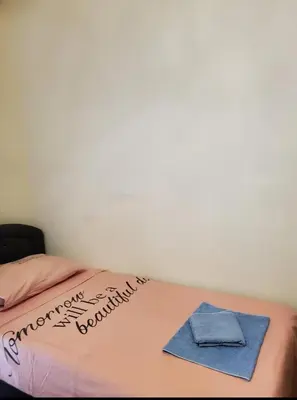 a bed with a pink blanket and a towel on it at Apartmani Sabotic in Sutomore