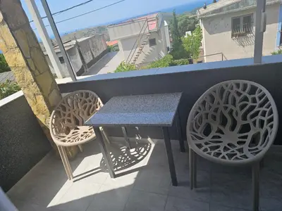 a table and two chairs on a balcony at Apartmani Sabotic in Sutomore