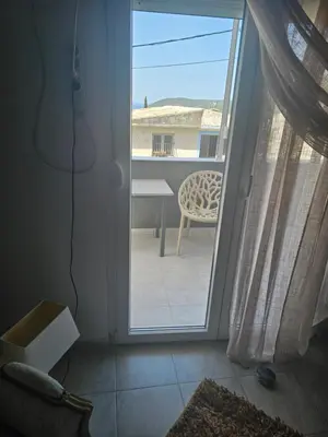 an open door to a patio with a table and a chair at Apartmani Sabotic in Sutomore