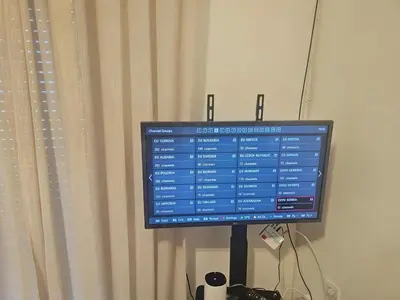 a computer monitor on a stand next to a curtain at Apartmani Sabotic in Sutomore