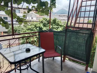 a red chair and a table on a balcony at Studio apartmani Dream Iv in Bar, Susanj