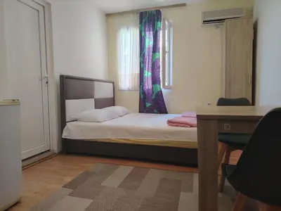 a bedroom with a bed and a desk and a window at Studio apartmani Dream Iv in Bar, Susanj