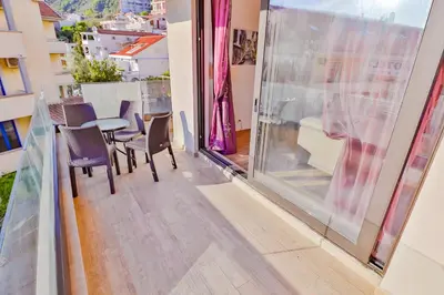 a balcony with a table and chairs and a view at Flat Rafailovic One minute to Beach in Budva
