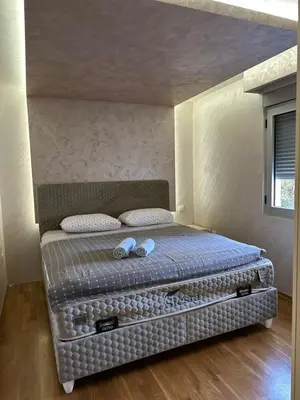 a bed in a room with two pillows on it at Lux apartment Rafailovići in Budva