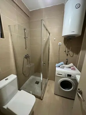 a bathroom with a shower and a washing machine at Lux apartment Rafailovići in Budva