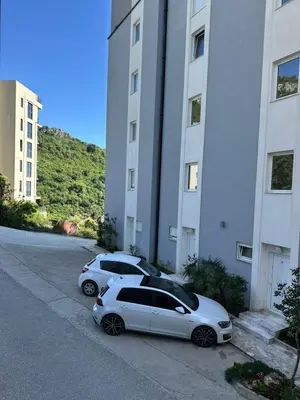 two cars parked in a parking lot next to a building at Lux apartment Rafailovići in Budva