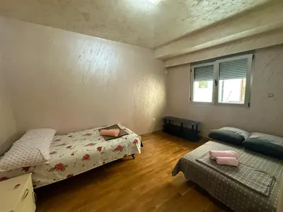 a bedroom with two beds and a couch and a window at Lux apartment Rafailovići in Budva