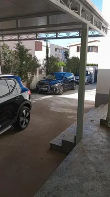 two cars are parked in a parking lot at Apartmani Vedrana in Sutomore