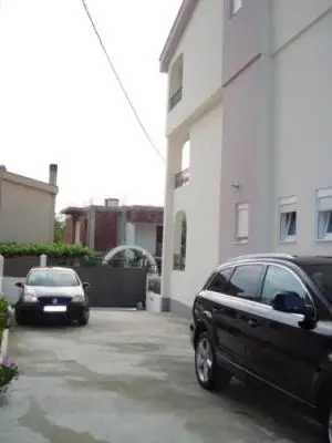two cars parked in a parking lot next to a building at Apartmani Vedrana in Sutomore