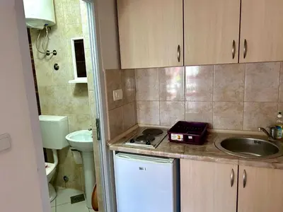 a small kitchen with a sink and a counter top at Apartmani Vedrana in Sutomore