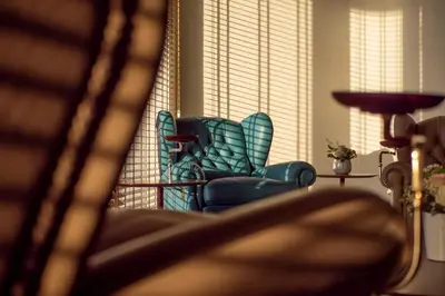 a blue chair sitting in a living room next to a window at Sea Star Budva in Budva
